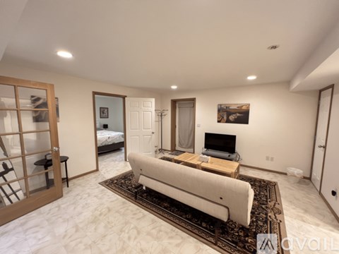 A living room with a white couch and a rug.
