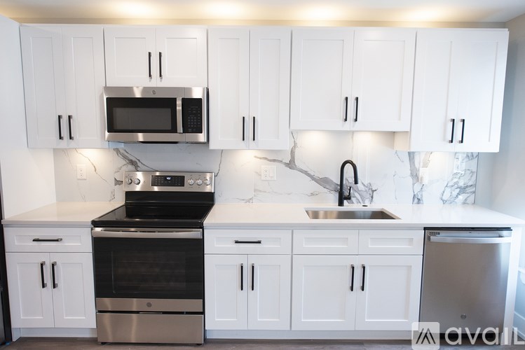 A kitchen with white cabinets and a black stove top oven.