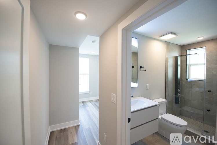 A bathroom with a toilet, sink, and mirror.