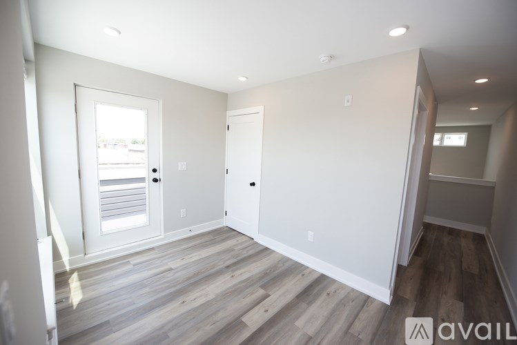 A room with wooden flooring and white walls.