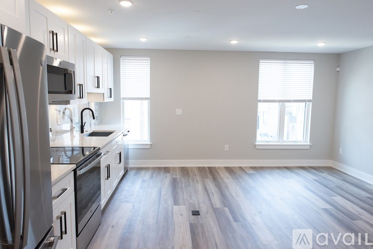 A kitchen with a refrigerator, microwave, and oven.
