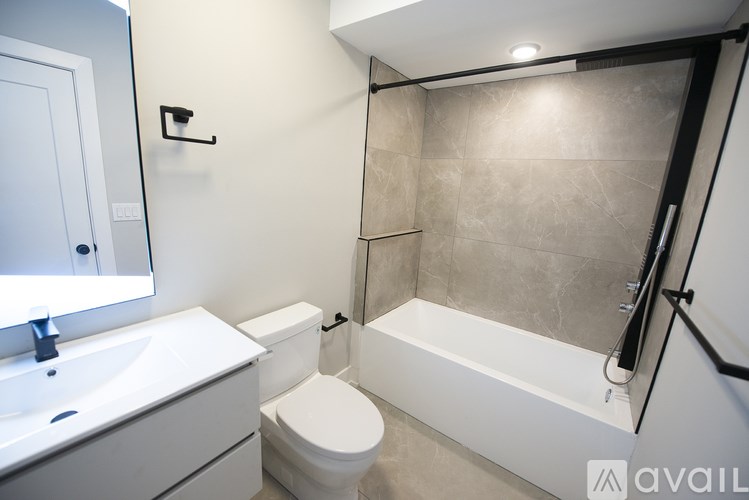 A bathroom with a toilet, sink, and bathtub.