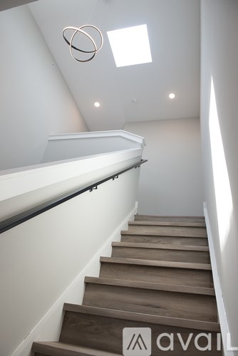 A staircase with wooden steps and a skylight above.