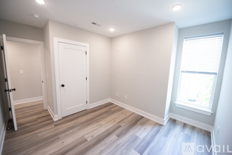 A room with a white door and a window with blinds.