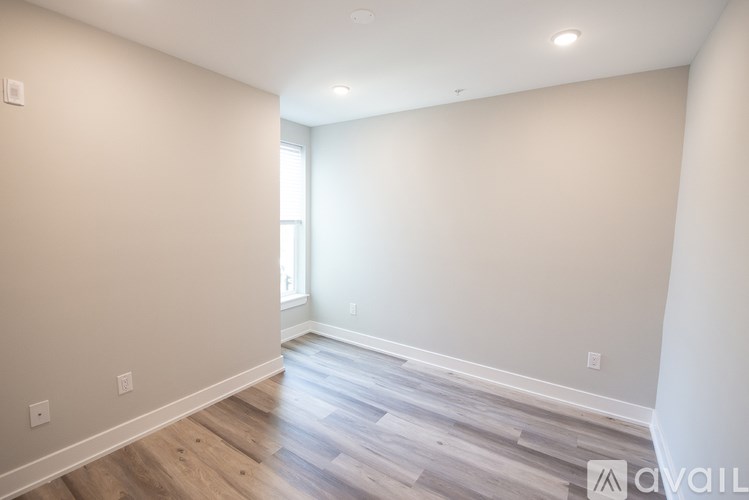 A room with wooden flooring and white walls.