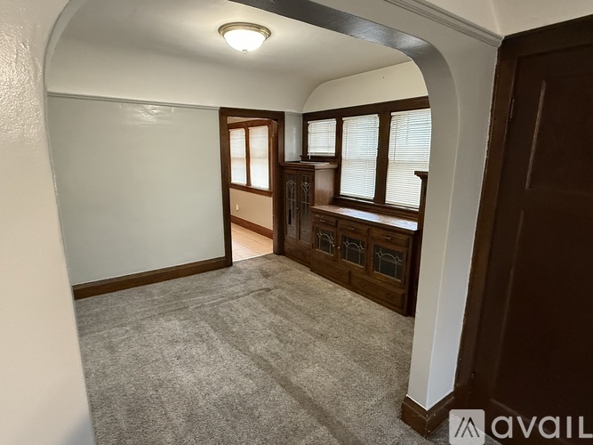 A room with a carpeted floor and a row of windows.