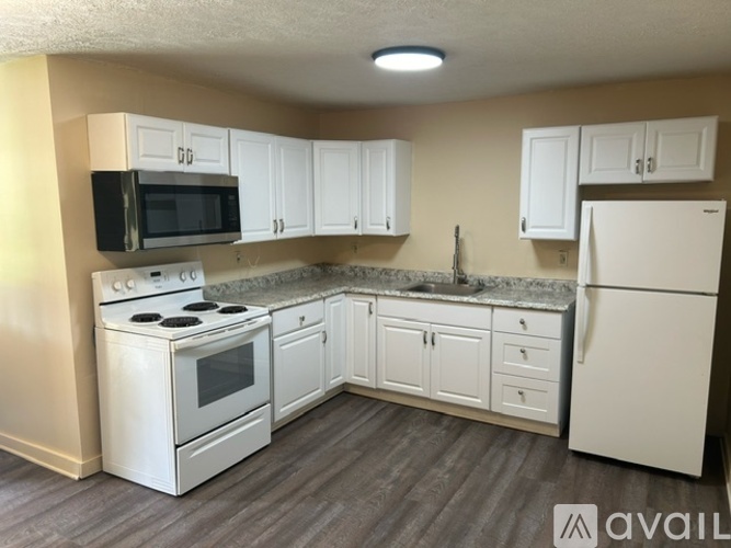 A kitchen with white appliances and cabinets.