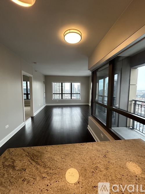 A spacious room with a large window and a balcony.