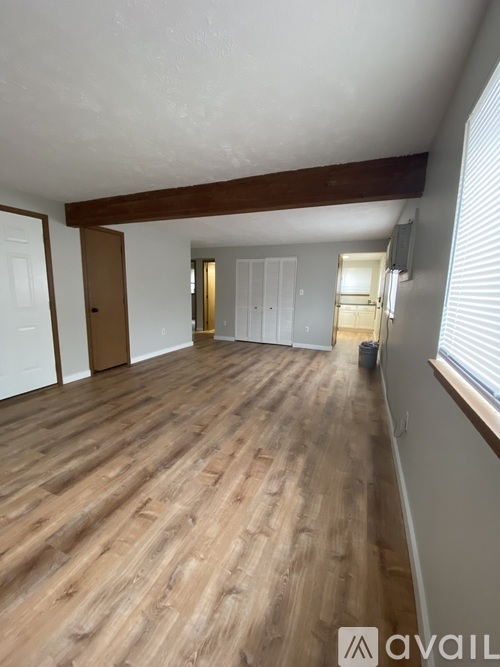 A room with wooden flooring and white walls.