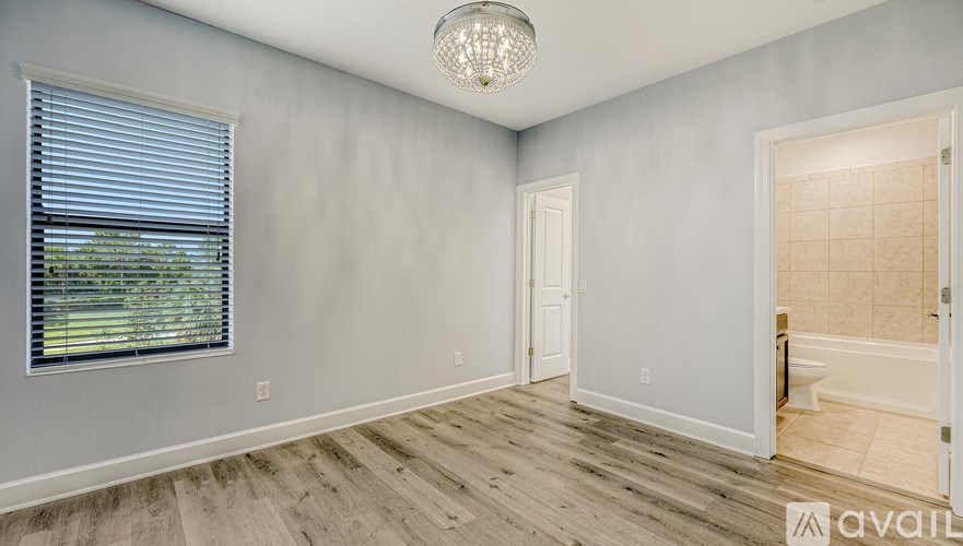 A room with a window, a door, and a chandelier.