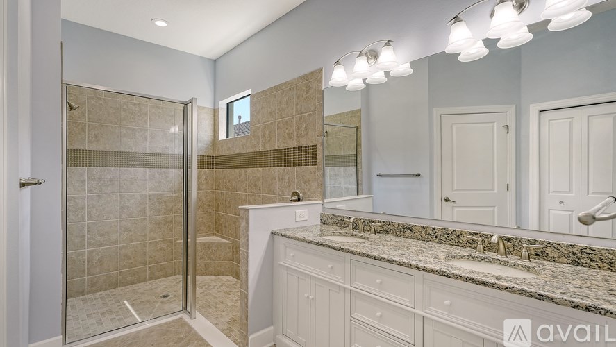 A bathroom with a marble countertop and a walk-in shower.