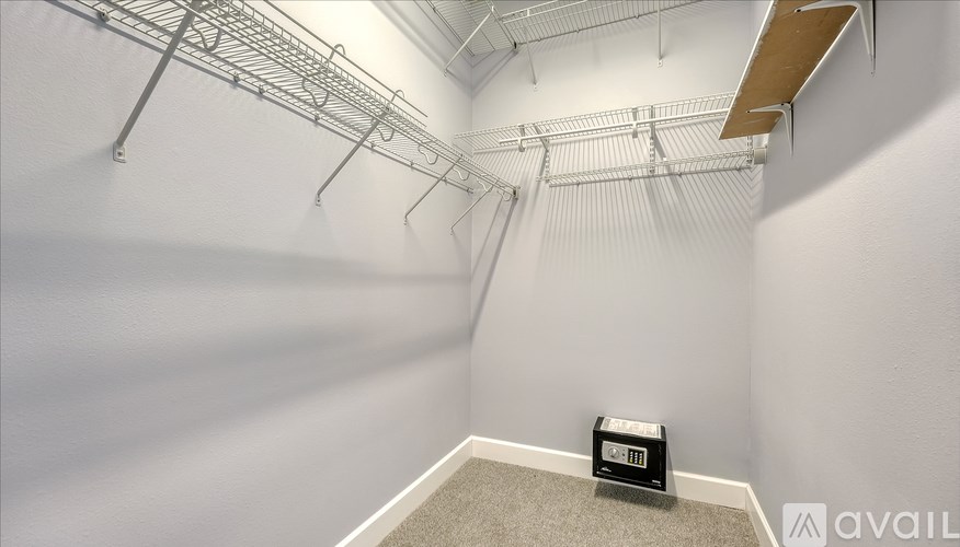 A small room with a metal rack on the wall and a digital clock on the floor.