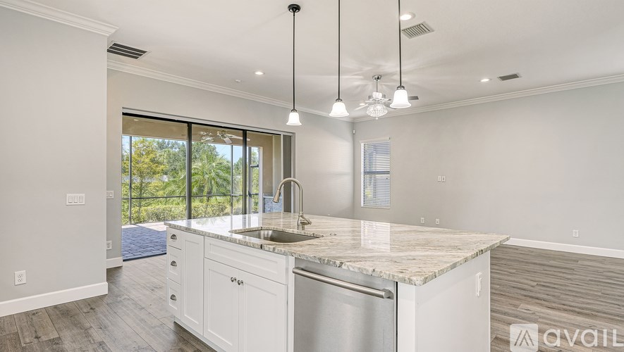A modern kitchen with a marble countertop and stainless steel appliances.