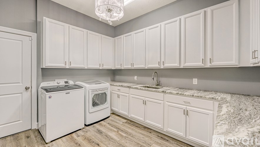 A kitchen with white cabinets and a marble countertop.