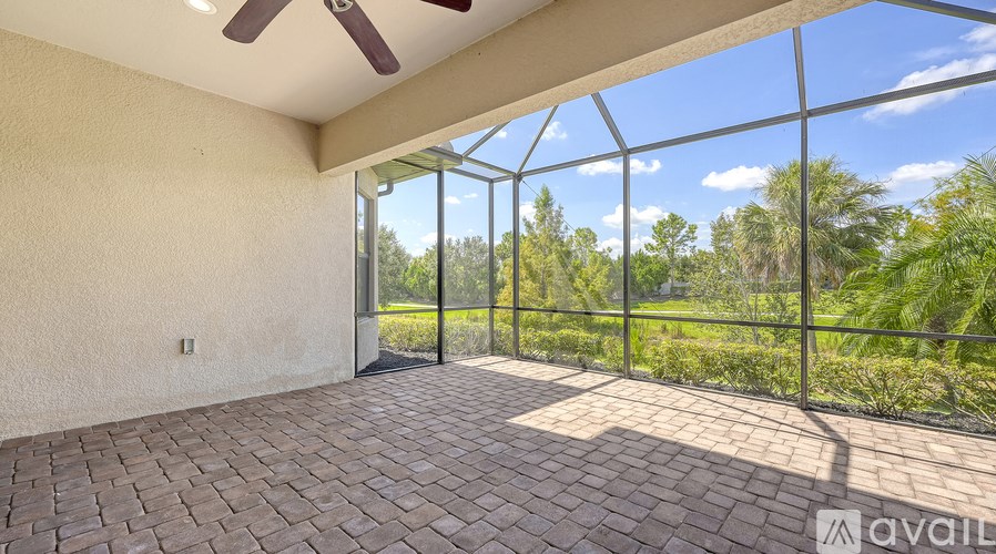 A patio with a ceiling fan and sliding glass doors.