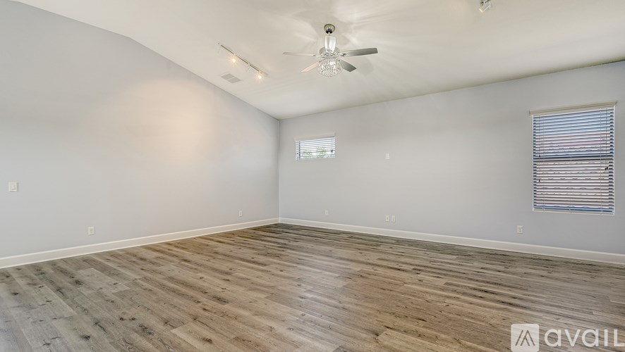 A room with wooden flooring and a ceiling fan.