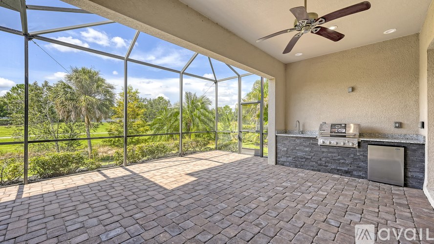 A patio with a brick floor and a ceiling fan.