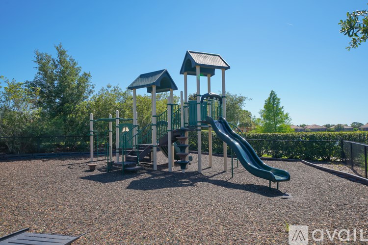 A playground with a green slide and two black and white towers.