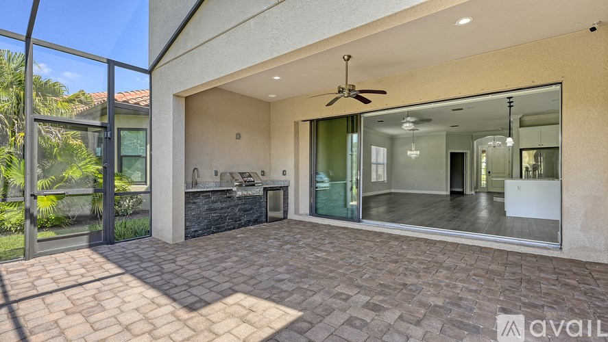 A patio area with a fan and sliding glass doors.