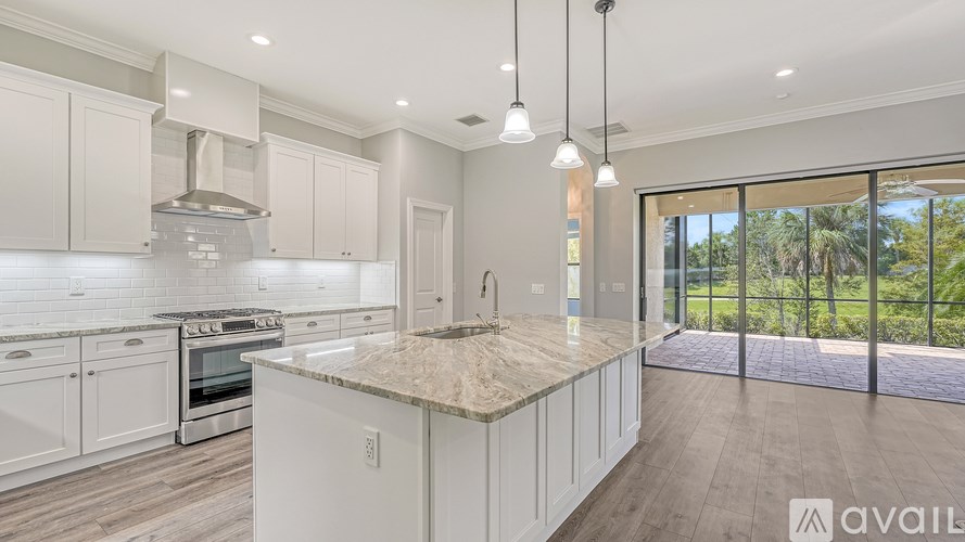 A modern kitchen with white cabinets and a marble countertop.