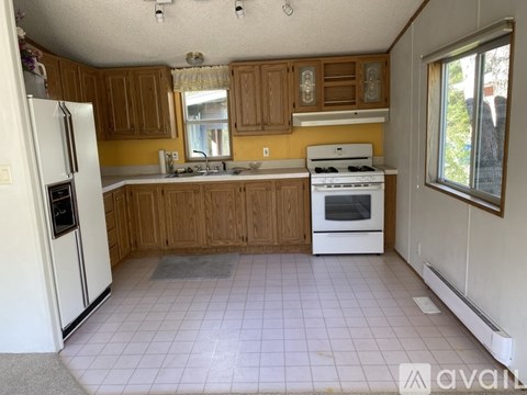 A kitchen with wooden cabinets and white appliances.