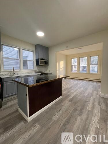 A kitchen with a wooden island and grey cabinets.