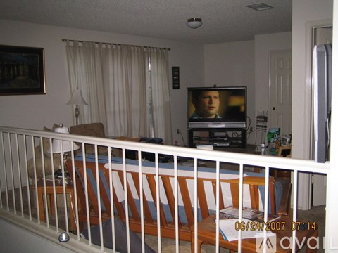 A living room with a television and a white railing.