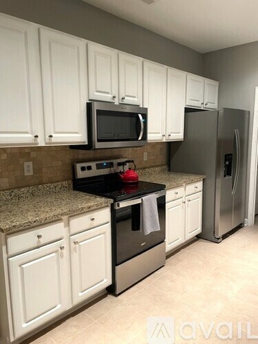 A kitchen with white cabinets and a granite counter top.