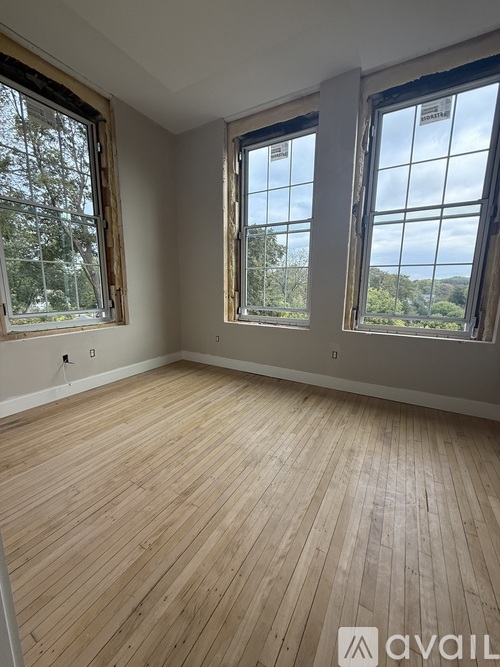 A kitchen with white cabinets and a wooden floor.