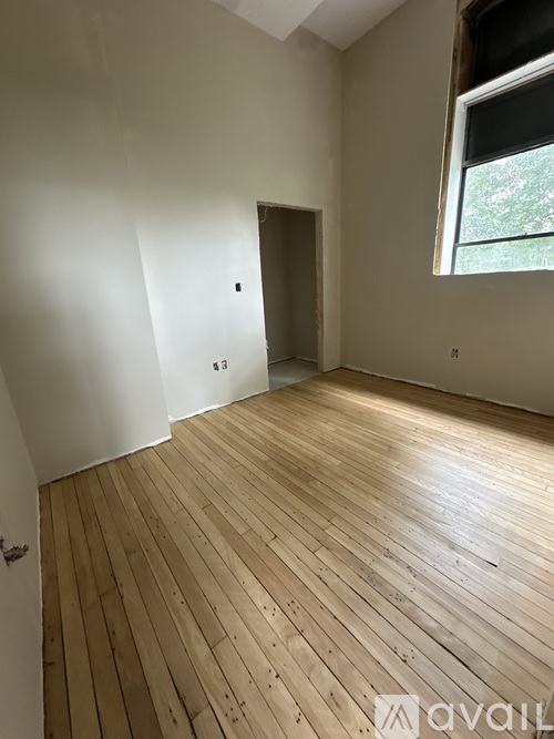 A room with wooden flooring and a window.