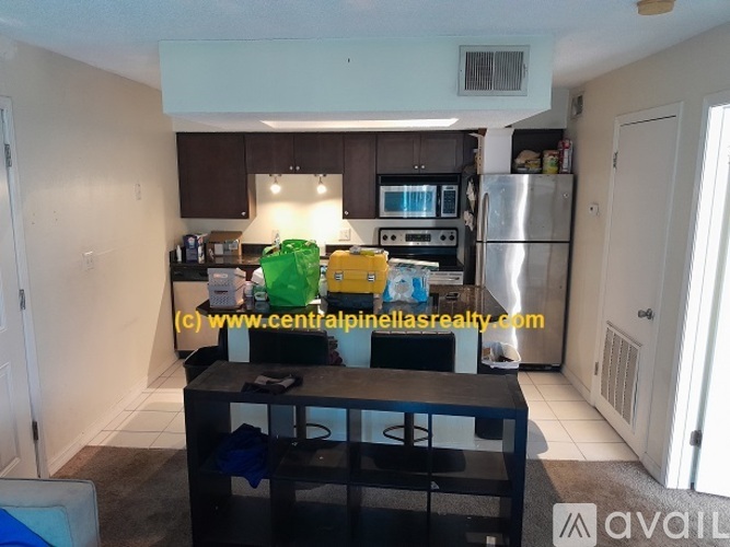 A kitchen with a refrigerator, microwave, and oven.