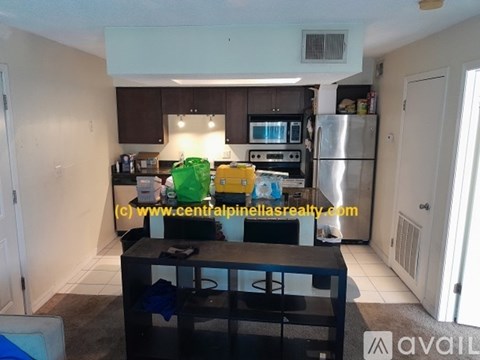 A kitchen with a refrigerator, microwave, and oven.