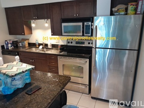 A kitchen with a stainless steel refrigerator, microwave, oven, and other appliances.