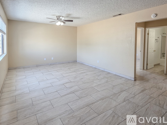 A room with a ceiling fan and tile flooring.