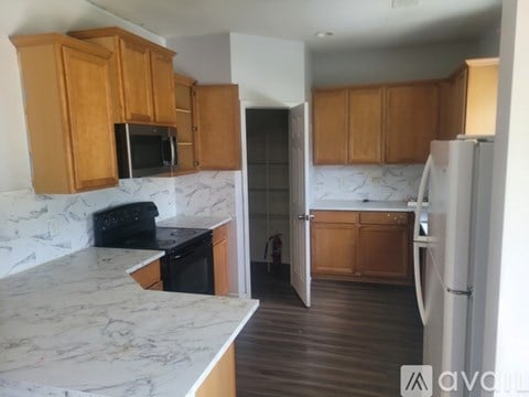 A kitchen with wooden cabinets and a marble countertop.
