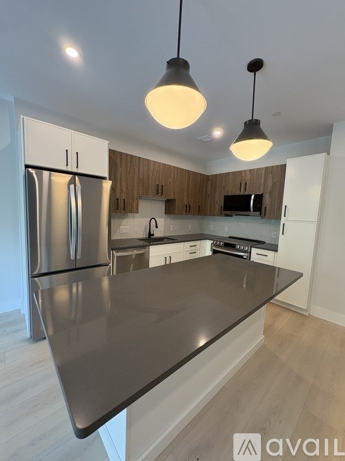 A kitchen with a refrigerator, cabinets, and a countertop.