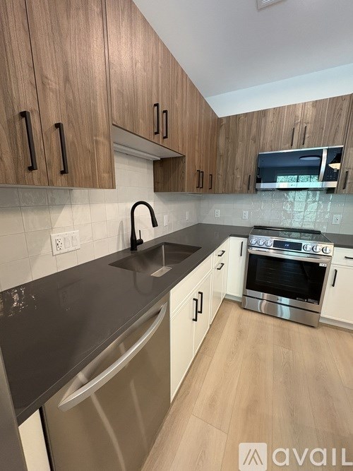 A kitchen with wooden cabinets and a stainless steel sink.