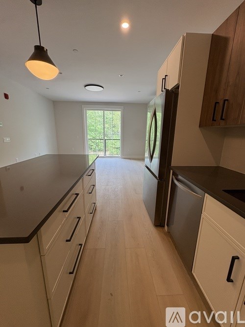 A kitchen with wooden cabinets and a black countertop.