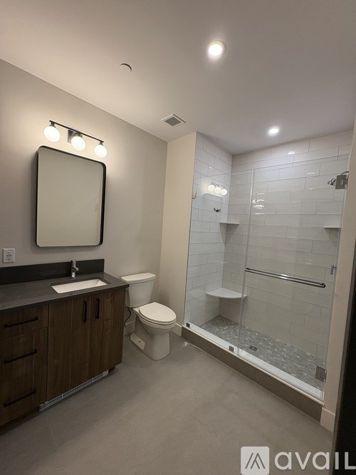 A bathroom with a toilet, sink, and shower.