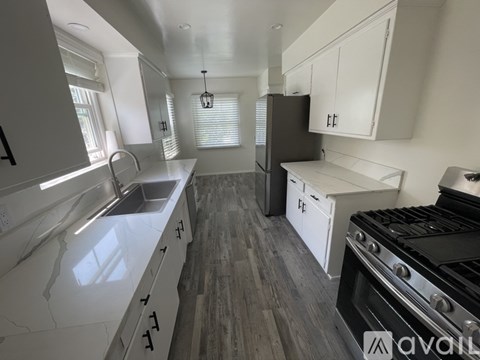 A kitchen with white cabinets and a black stove top oven.