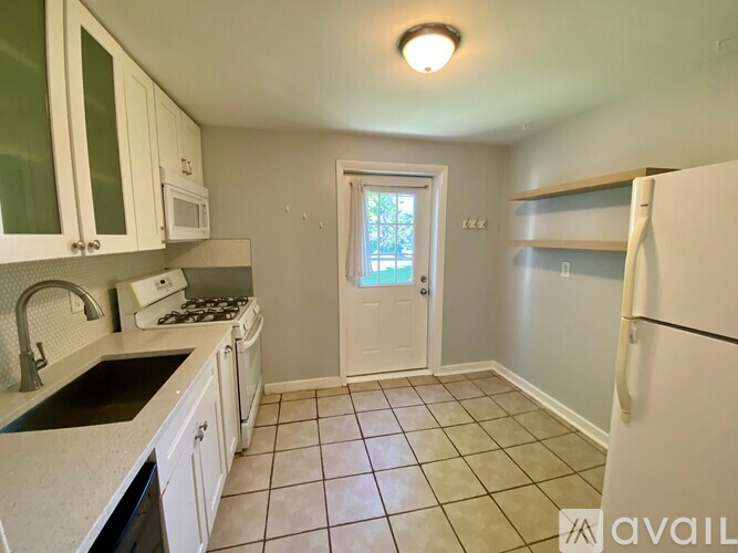 A kitchen with white cabinets and a black countertop.