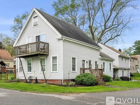 A two-story house with a balcony on the second floor.