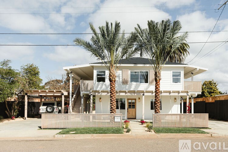 A house with a white exterior and a porch with a wooden railing.