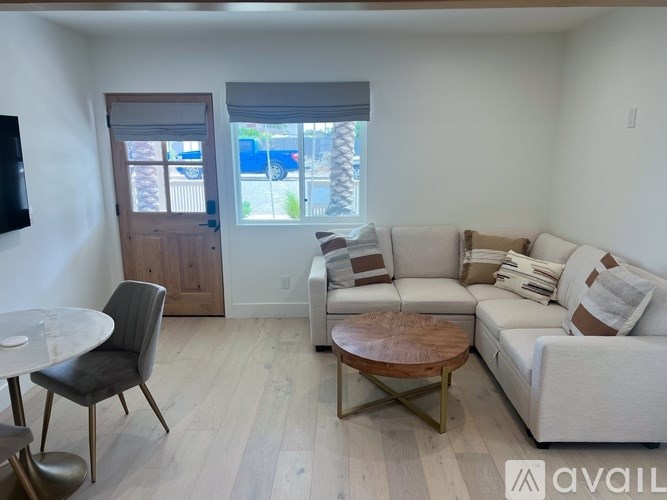 A living room with a white couch, a grey chair, and a wooden coffee table.