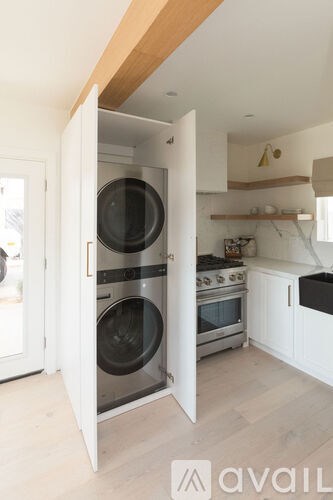 A modern kitchen with a washing machine built into the cabinetry.