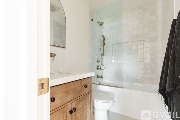 A bathroom with a white toilet and a glass shower door.