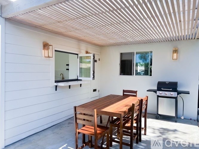 A wooden table is set outside on a patio.