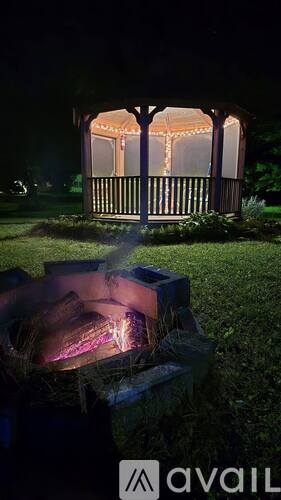 A gazebo is lit up at night with string lights.