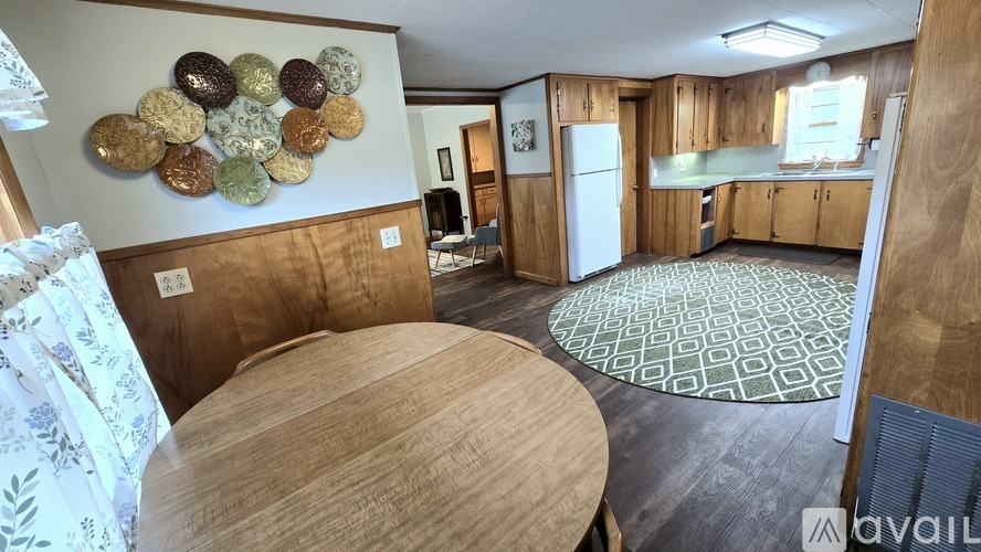 A kitchen with a wooden table and a wall hanging of coins.