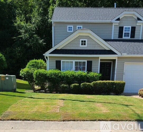 A house with a grey roof and a black door.
